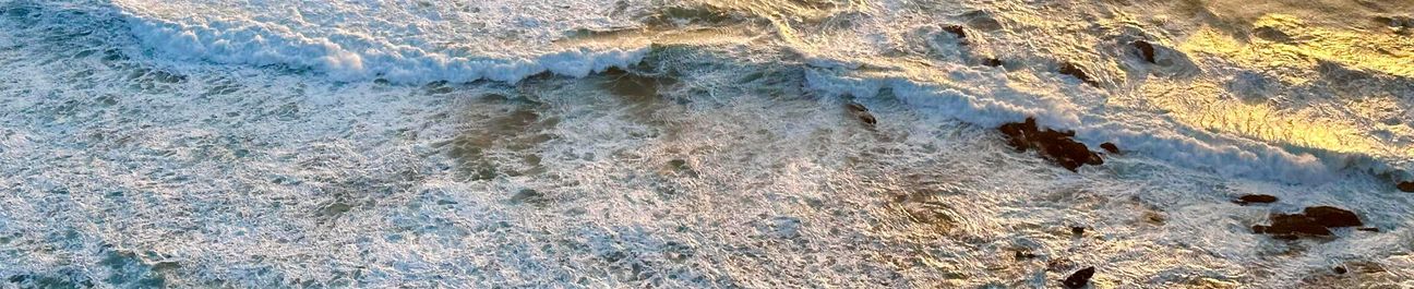 Ocean waves washing over rocks at sunset